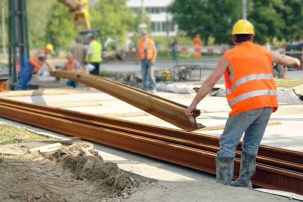 construction workers moving iron joists.